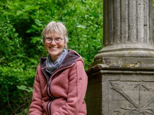 Auf dem Hagedorndenkmal sitzt die Stadtführerin Marion Iselt.