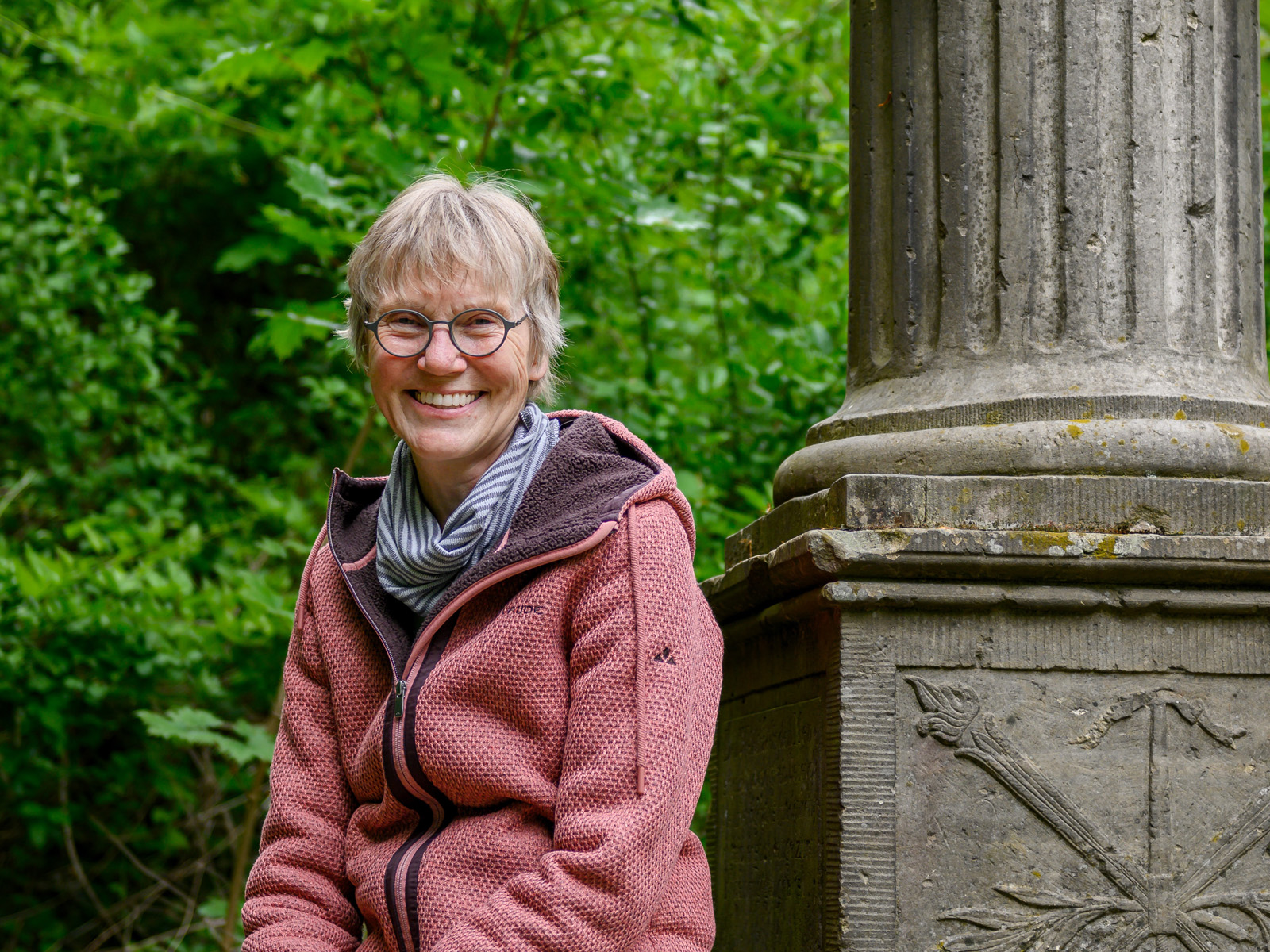 Auf dem Hagedorndenkmal sitzt die Stadtführerin Marion Iselt.